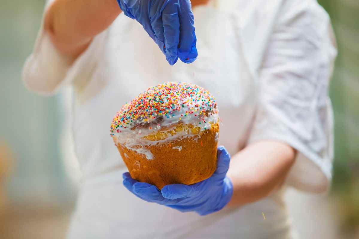 una mano guarnisce la torta pasqualina