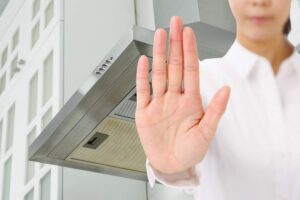 donna con mano in segno di stop e cappa sullo sfondo