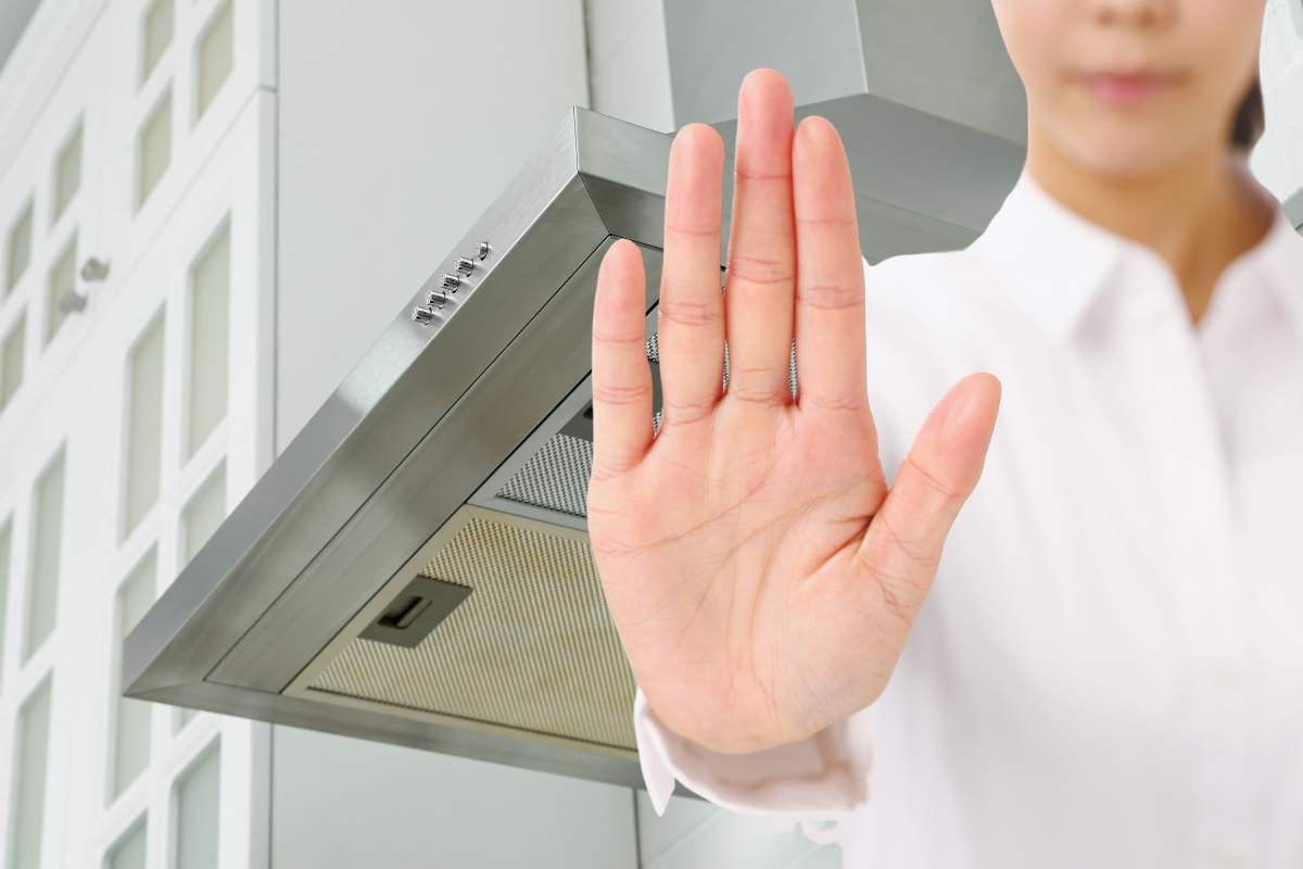 donna con mano in segno di stop e cappa sullo sfondo