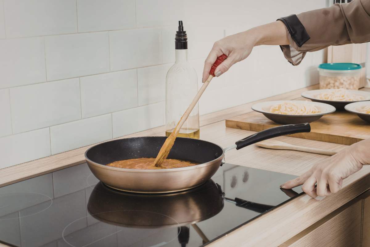 donna che cucina su piano ad induzione