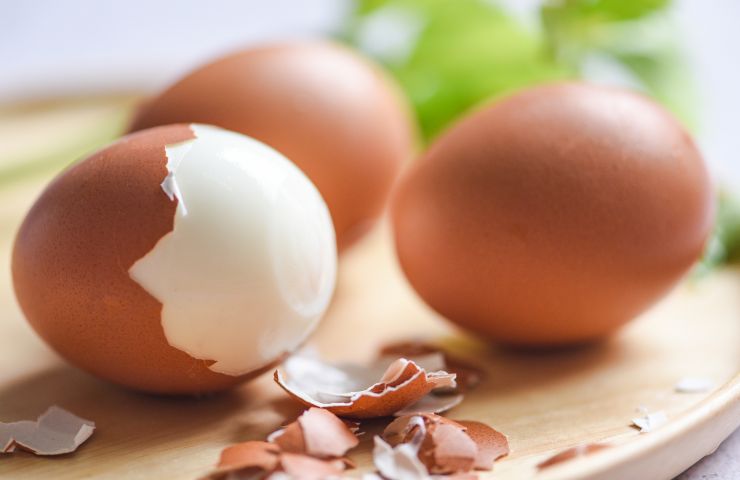 uova sode da sbucciare su tagliere di legno